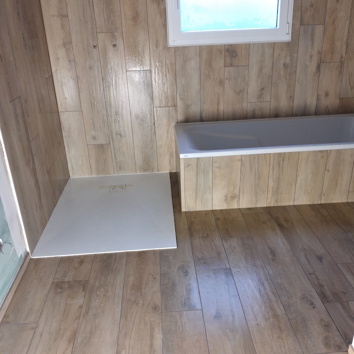 Salle de bain : carrelage effet bois, douche et baignoire